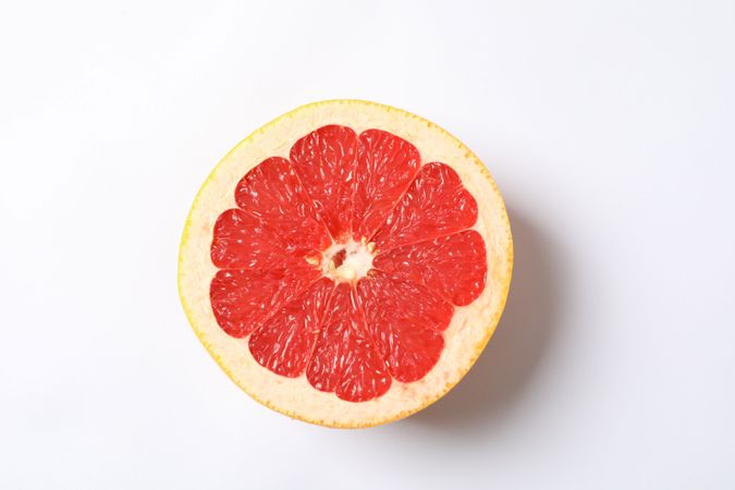 Grapefruit slice on blank background, space for text