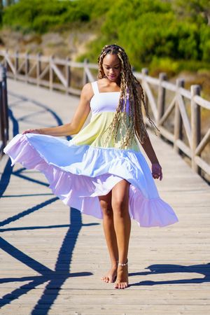 Female looking down and walking on a pedestrian walkway in colorful dress