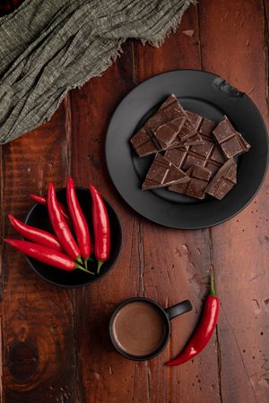 Hot beverage near plate with chocolate and pepper