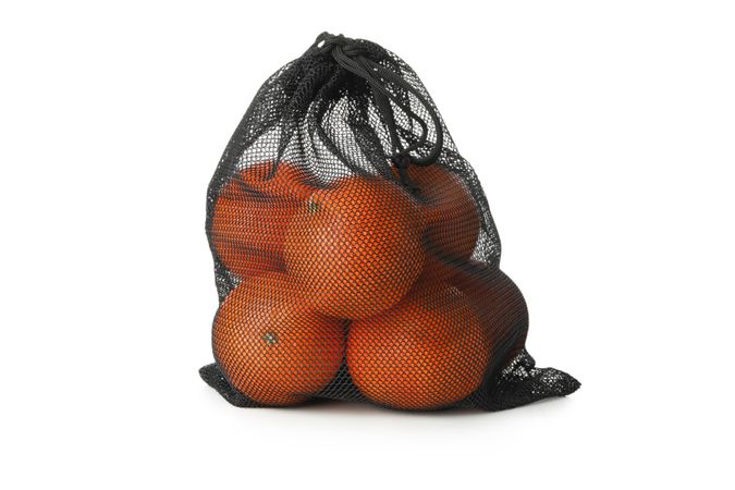 String bag with ripe mandarins isolated on light background