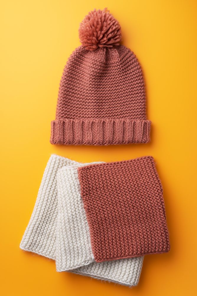 Beanie and scarf on orange background