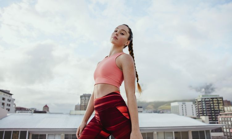 Confident young woman in sportswear standing outdoors