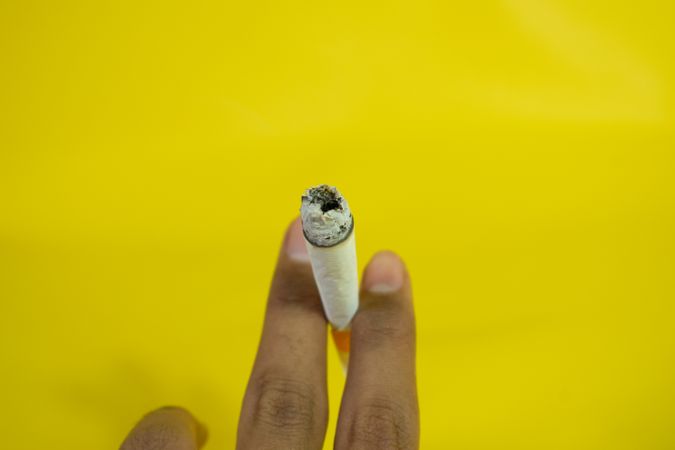 Top view of hand holding lit cigarette