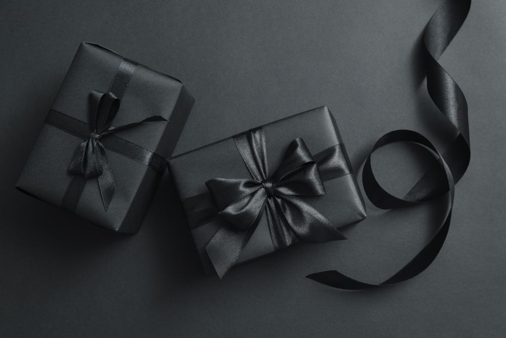Gift boxes with dark bows on dark background