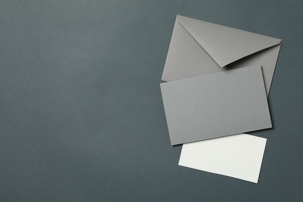 Blank envelope and cards on light dark background, space for text