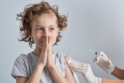 Faceless nurse vaccinating nervous child