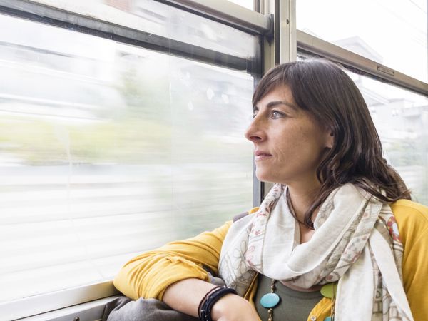 Woman looking through window inside of train