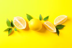 Flat lay composition with lemons on color background, space for text