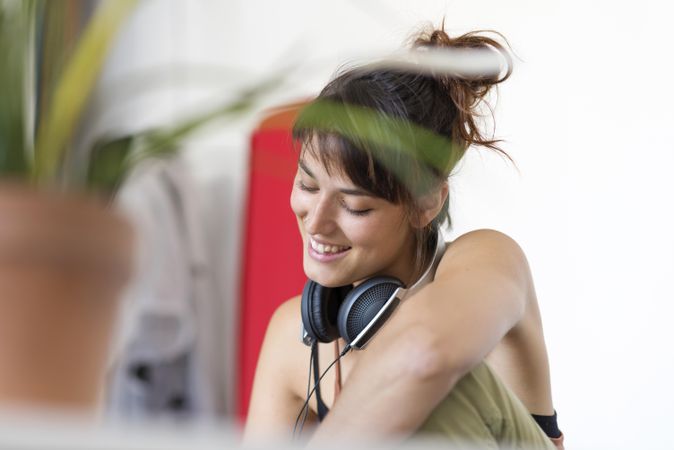 Amused female behind plant in bright room