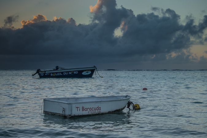 Two simple boats in the Indian Ocean under clouds at dusk