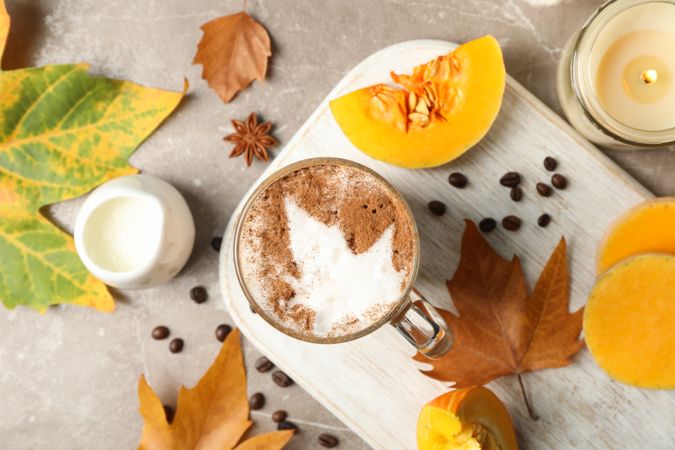 Composition with glass cup of pumpkin latte on gray background