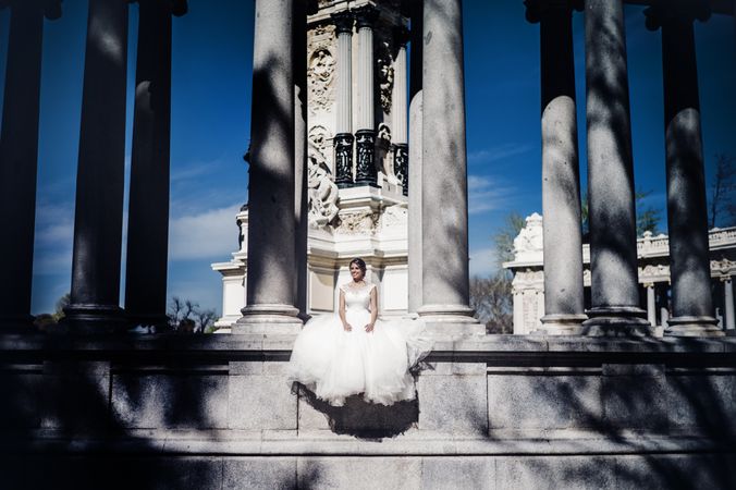 Smiling fiancee sitting near columns