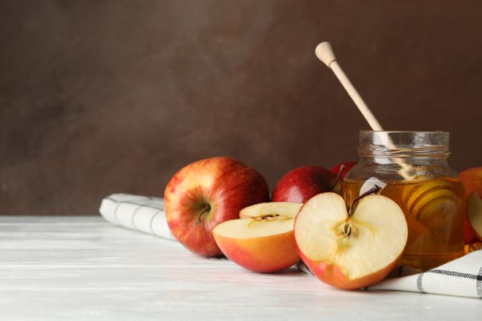 Side view of apples and honey on kitchen towel with copy space