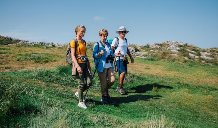 Older adults hiking with their daughter on clear day