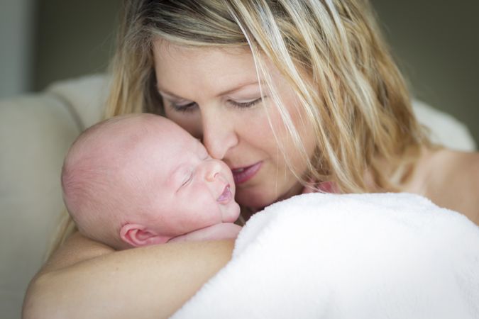 Young Mother Holding Her Precious Newborn Baby Girl