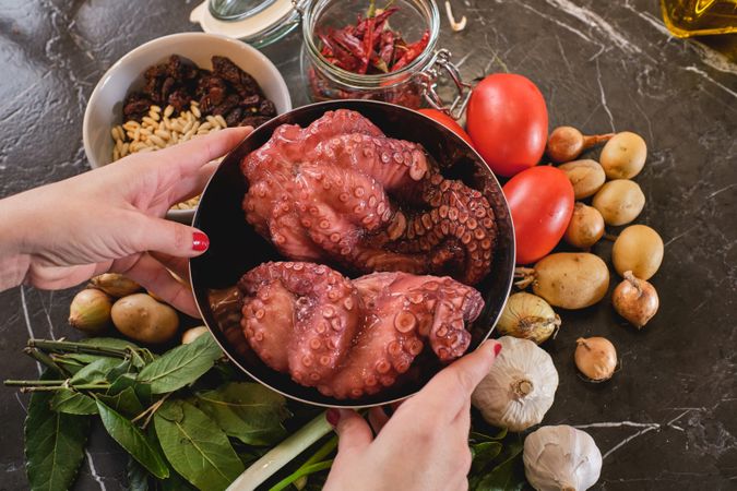 Anonymous woman preparing raw octopus