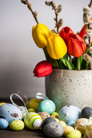 Easter card concept with eggs on table with vase of tulips