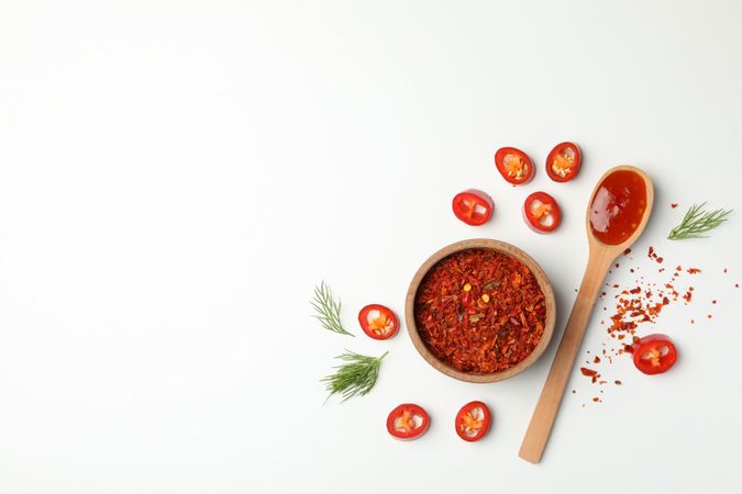 Composition with chilli pepper, spice and sauce on studio background