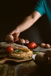 Crop man holding eggs near pie
