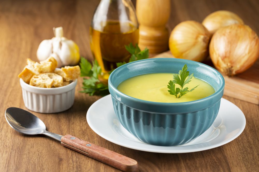 Bowl with onion soup and croutons on the table.