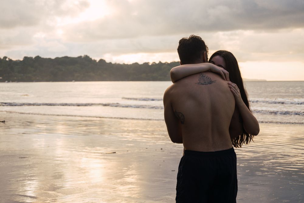 Young couple embracing on the beach at sunset