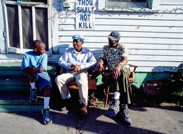 Three people relax in front of a home, Louisiana