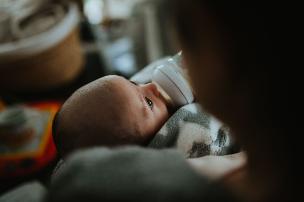 Top view of newborn being bottle fed
