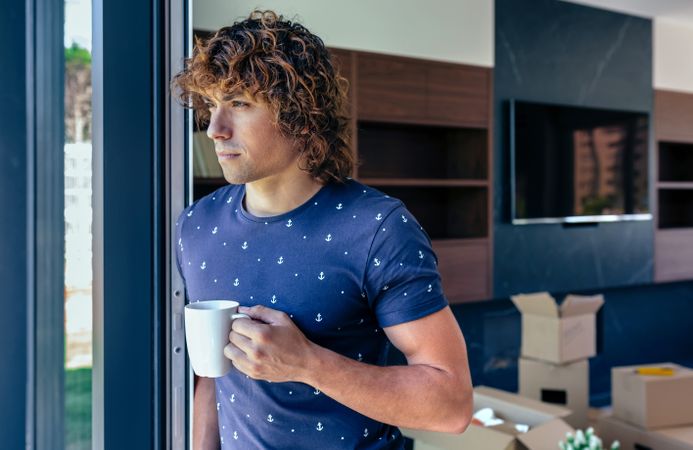 Man resting from unpacking moving boxes