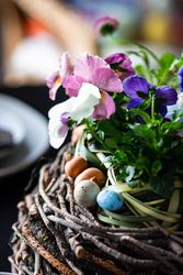 Close up of spring table setting with centerpiece of giant nest and flowers