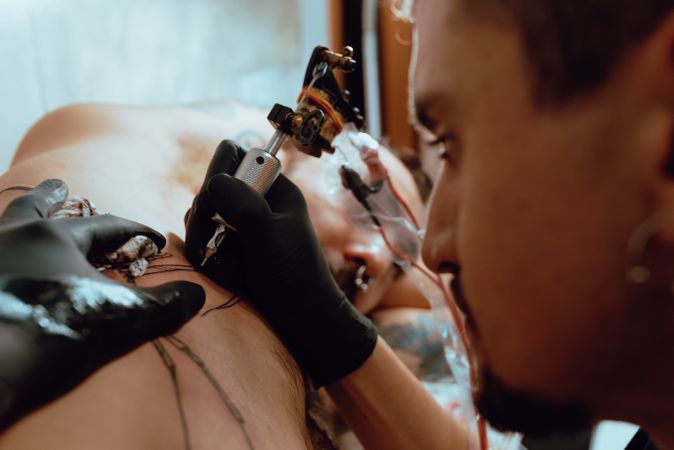 Man receiving tattoo on upper body