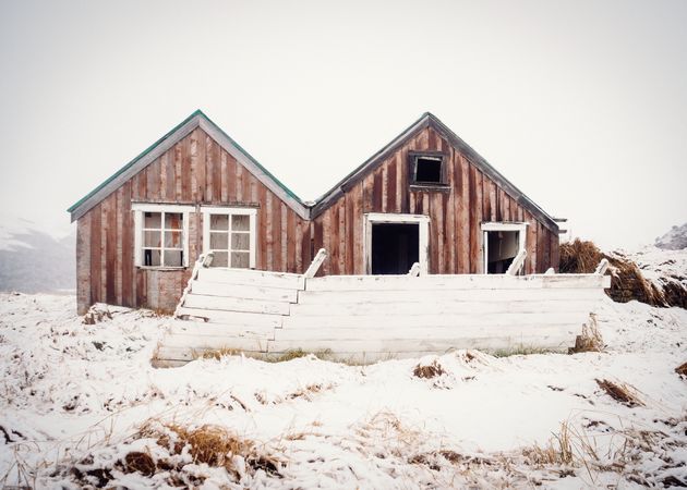 Deserted house between snowy field