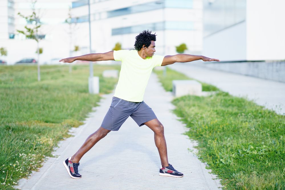 Side view of man doing yoga pose on lane