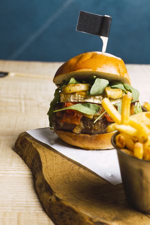 Juicy delicious burger and fried potato on table