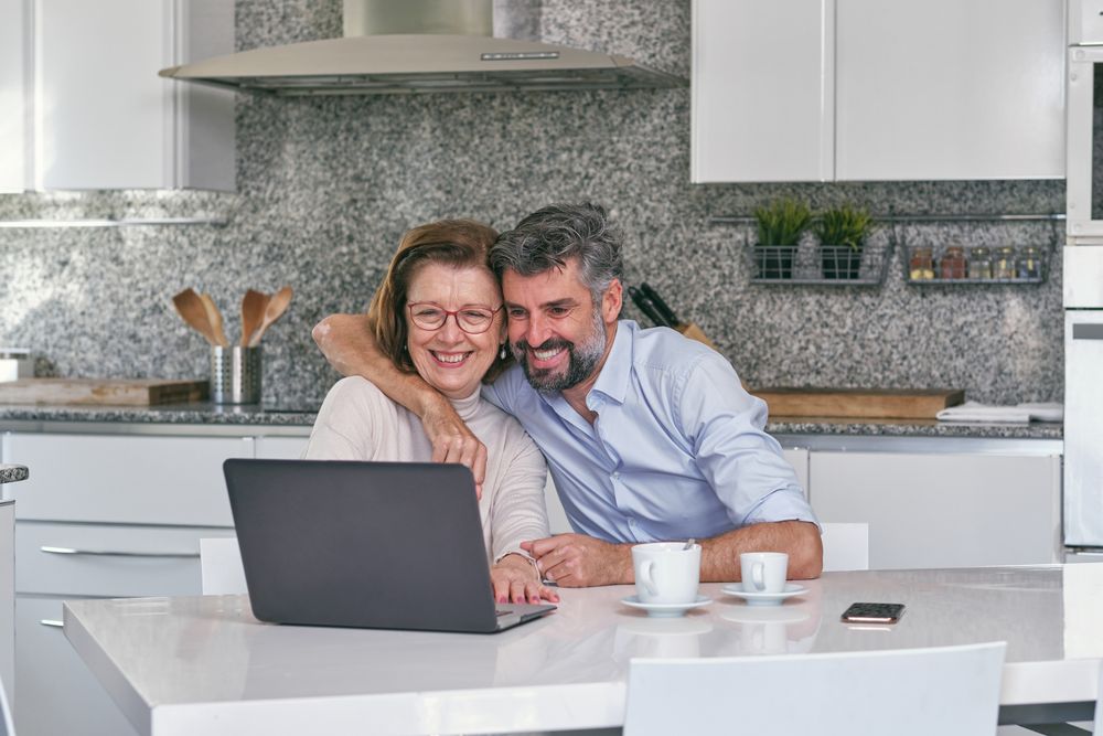 Mother and son having fun while watching video on laptop