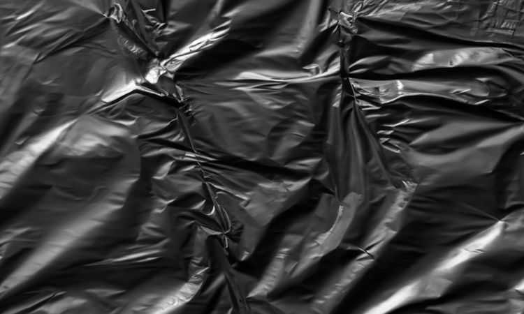 dark crumpled and creased plastic poster texture background