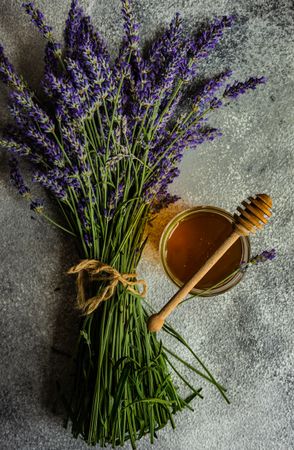 Top view of honey jar on napkin with dipper and bunch of lavender