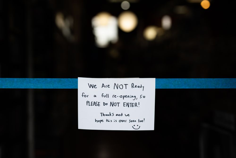 Sign hanging with duct tape across entrance to store stopping entry