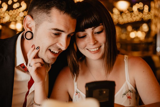 Couple using smartphone in luxury restaurant