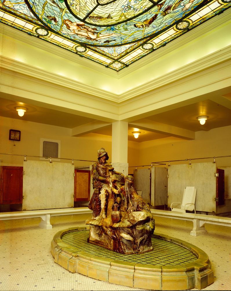 Stone statue and intricate stained glass skylight in bath house