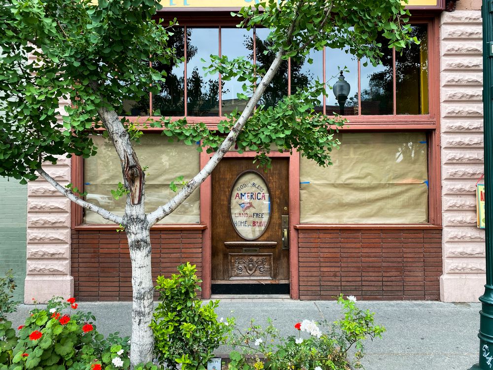 Wide view of closed pub and restaurant with windows covered in brown paper