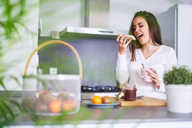 Smiling woman making sandwiches in kitchen