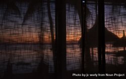 Tropical sunset behind hotel curtains 41OBp0