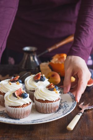 Oven baked cupcakes with cream frosting and fruit on top