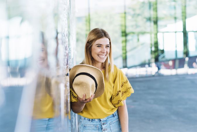 Woman with blue eyes holding straw hat