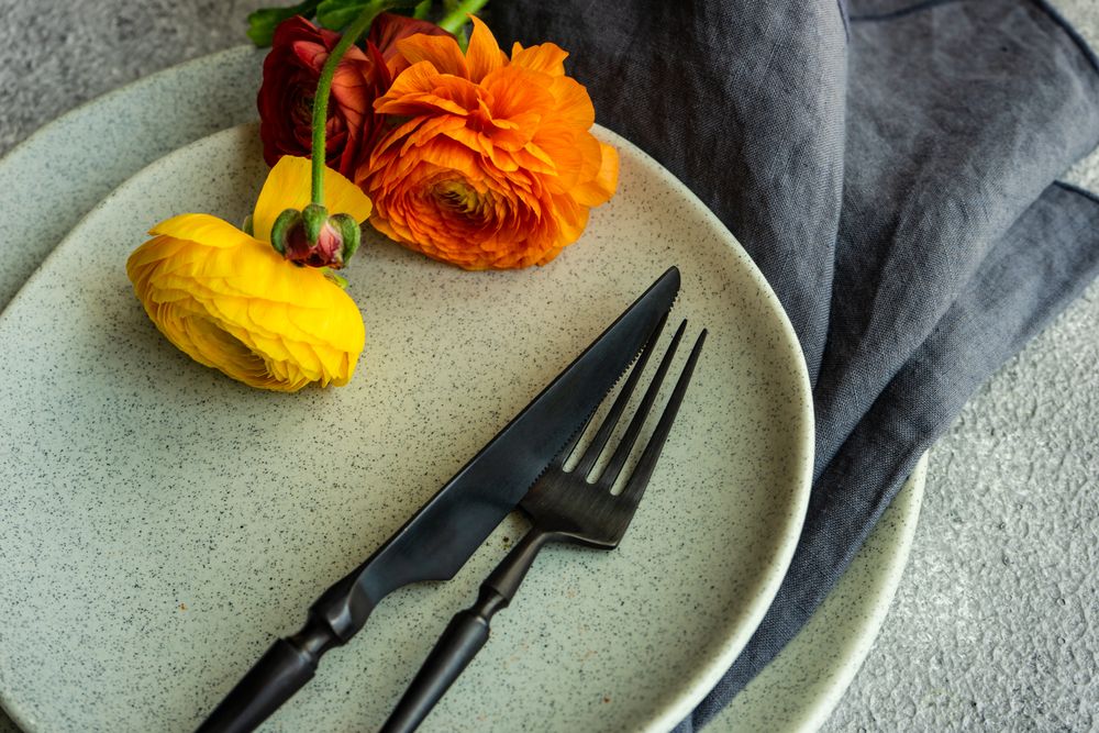 Rustic table setting with ranunculus flowers on grey plate