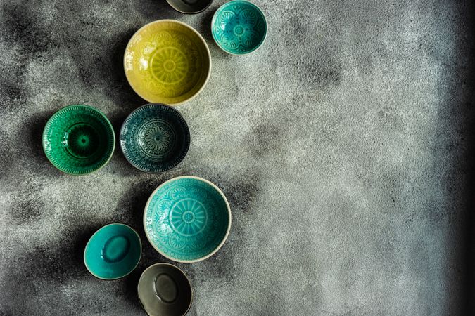 Empty colorful ceramic bowls on stone background