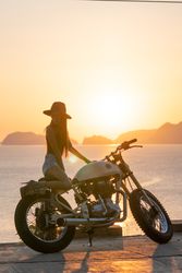 Woman with motorbike near sea