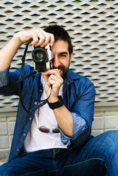 Smiling man in denim taking photo