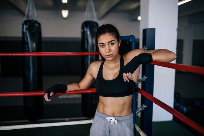 Female boxer leaning on the boxing ring