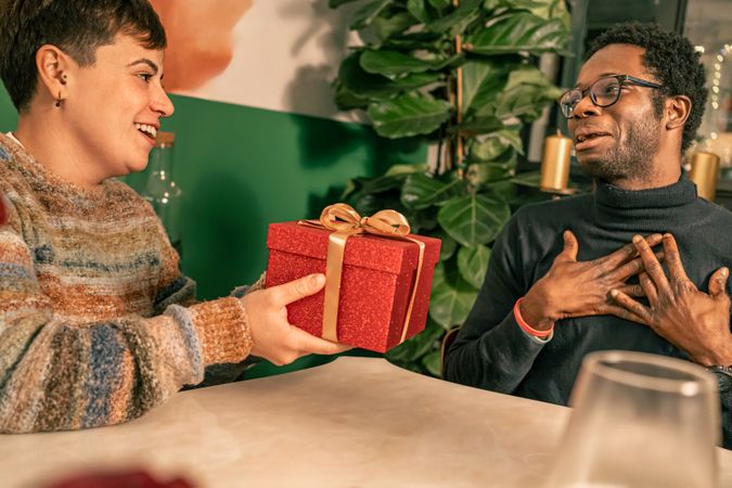 Man feeling grateful for a surprise gift from his partner during a celebration